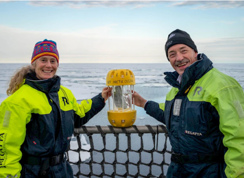 ELIZABETH MCLANAHAN, VICE CHAIR OF PAME AND DIRECTOR AT NOAA, AND OLE ARVE MISUND, DIRECTOR OF THE NORWEGIAN POLAR INSTITUTE (2017-2023) STAND WITH THE PLASTIC IN A BOTTLE CAPSULE ABOARD THE RV KRONPRINS HAAKON. © JESSICA COOK / ARCTIC COUNCIL SECRETARIAT